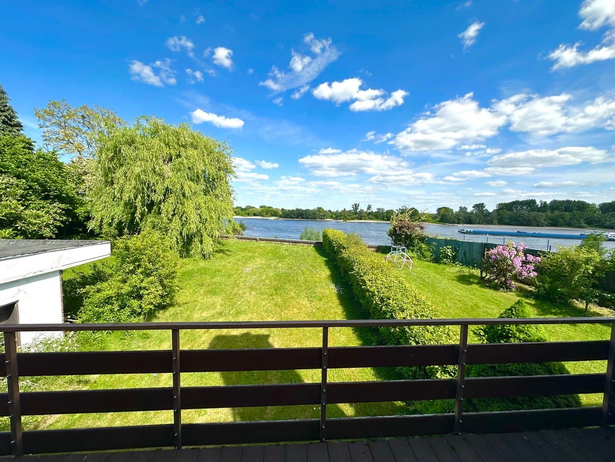 Blick vom Balkon über den Garten auf den Rhein und die gegenüberliegende Uferseite