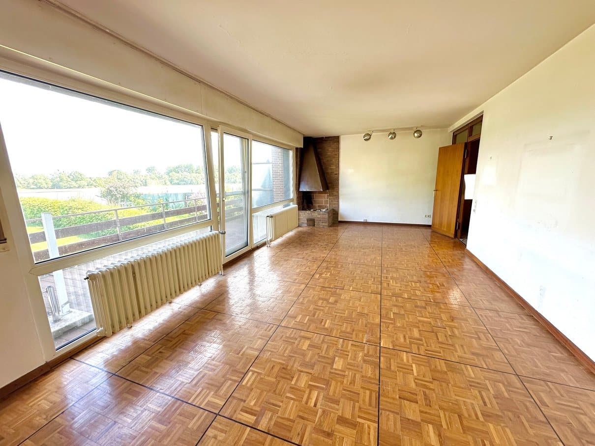 Wohnzimmer mit Parkettboden und Fensterfront